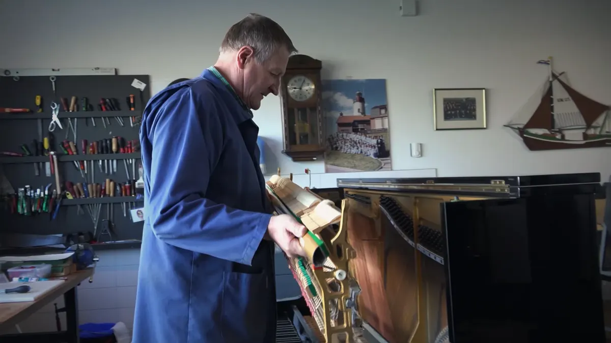 Pianotechnicus werkt aan het mechaniek van een vleugel in de werkplaats van Muziekhuis Souman