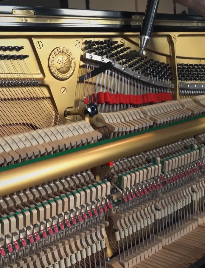 Pianotechnicus stemt een vleugel in de werkplaats van Muziekhuis Souman